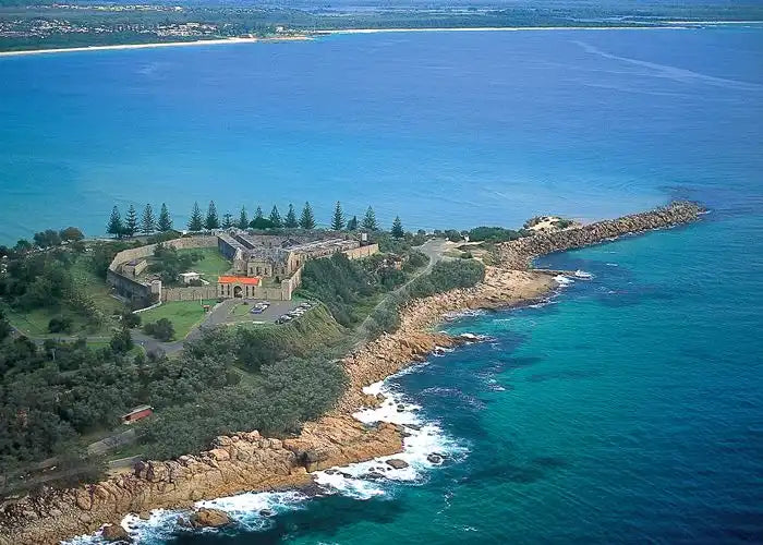 Historic lighthouse and keeper’s quarters perched on a rocky coastal headland.