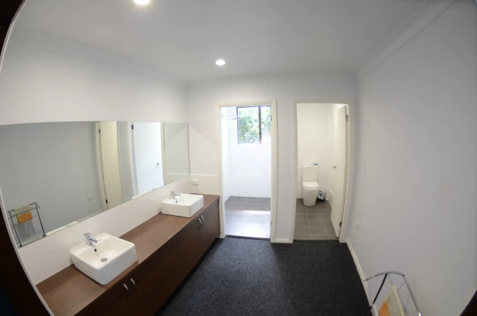 Modern bathroom vanity with dual sinks and wooden cabinetry.